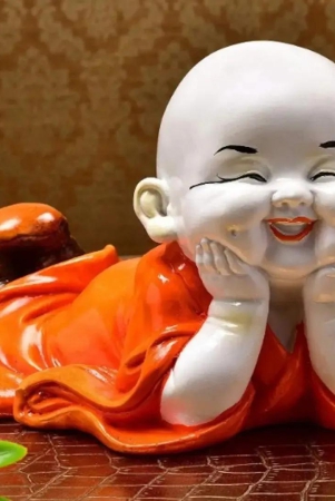 Glowing & Resting Laughing Baby Buddha Wearing Orange Robe Cute Child Monk Statue Marble Finish Handicrafted Home Office Décor Decorative Showpiece (Polyresin, Orange)